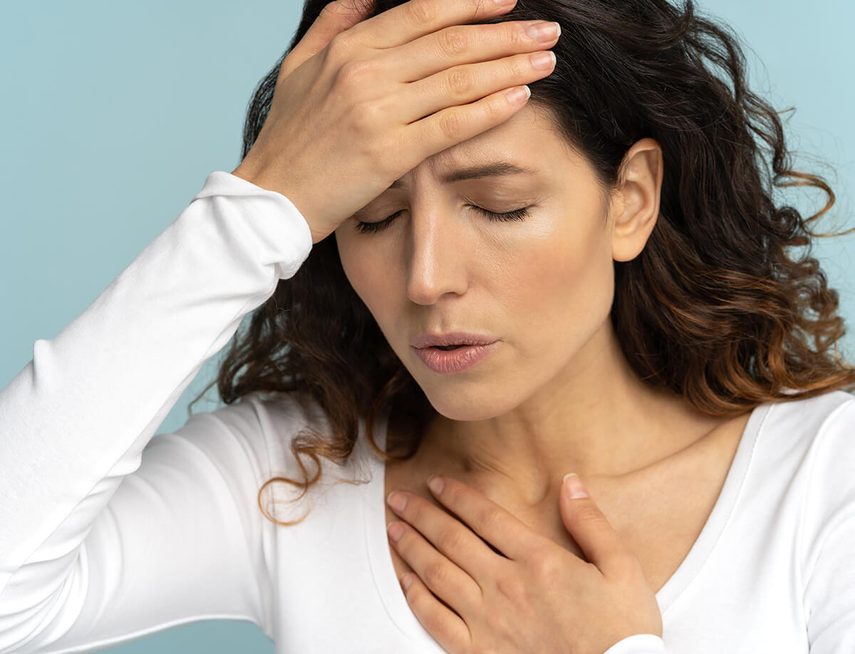 Woman holding her hands on her forehead and chest