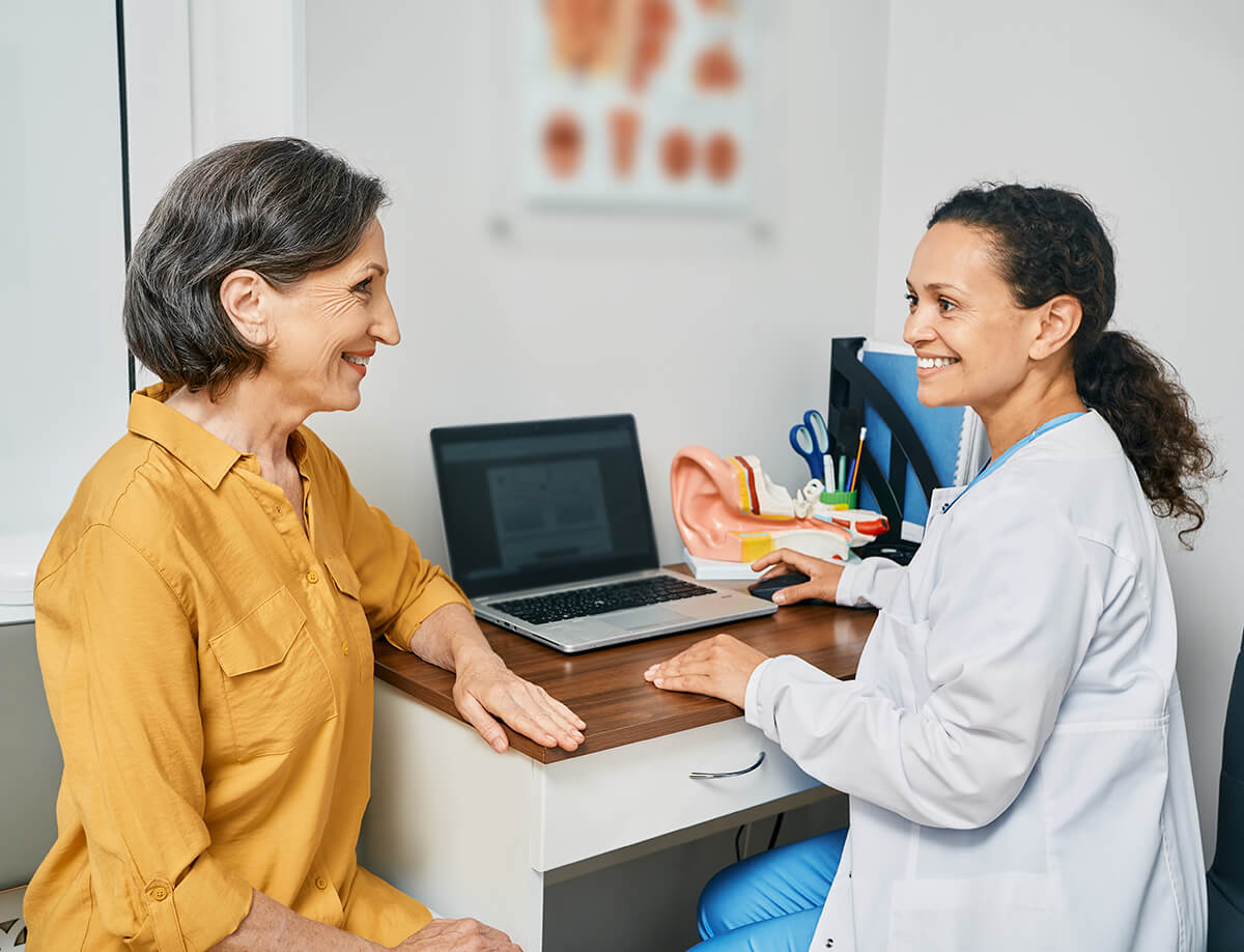 Audiologist and patient at a desk