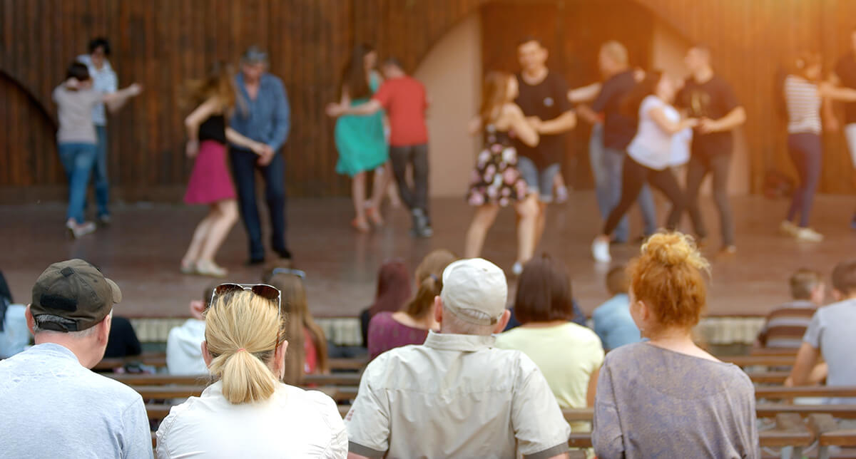 People dancing outdoors on a stage